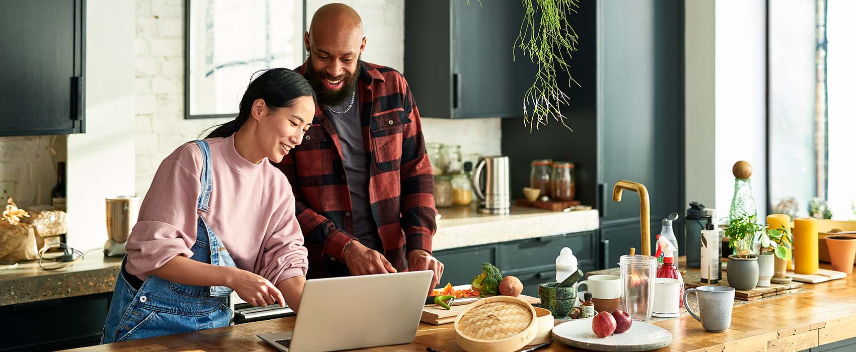 Couple looking at recipes on a laptop in their kitchen.