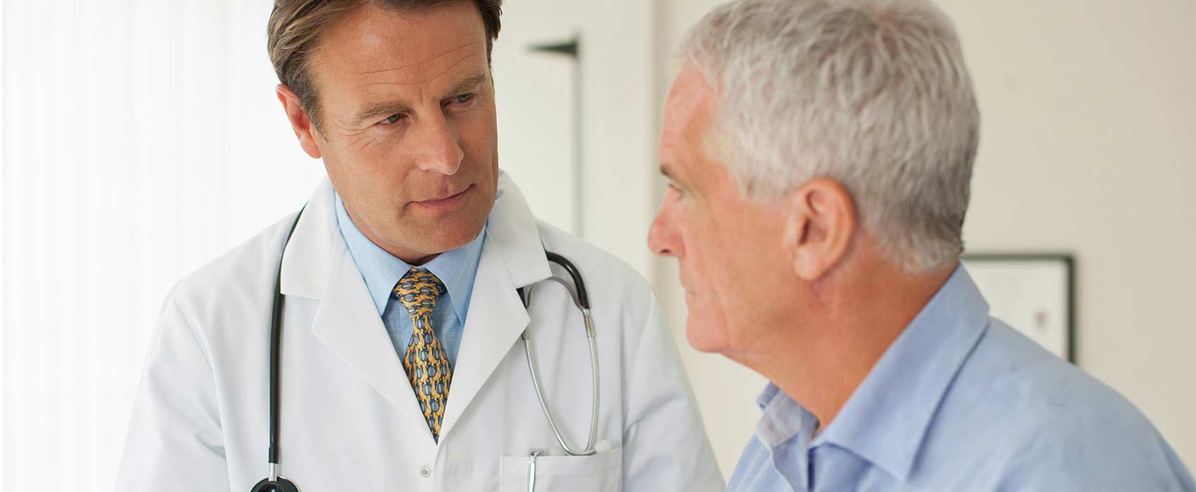 mature man speaking with doctor 