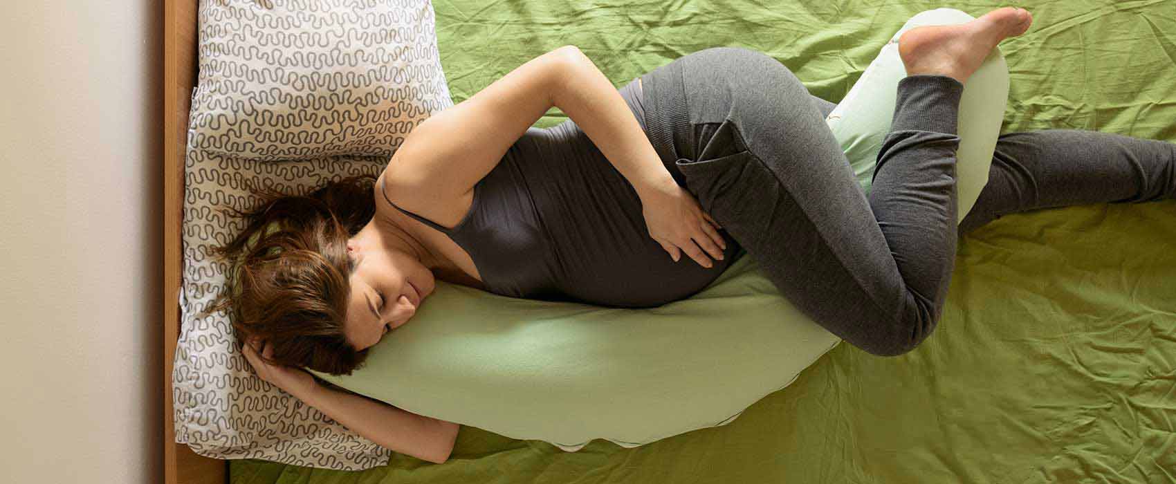 pregnant mother in bed with body pillow
