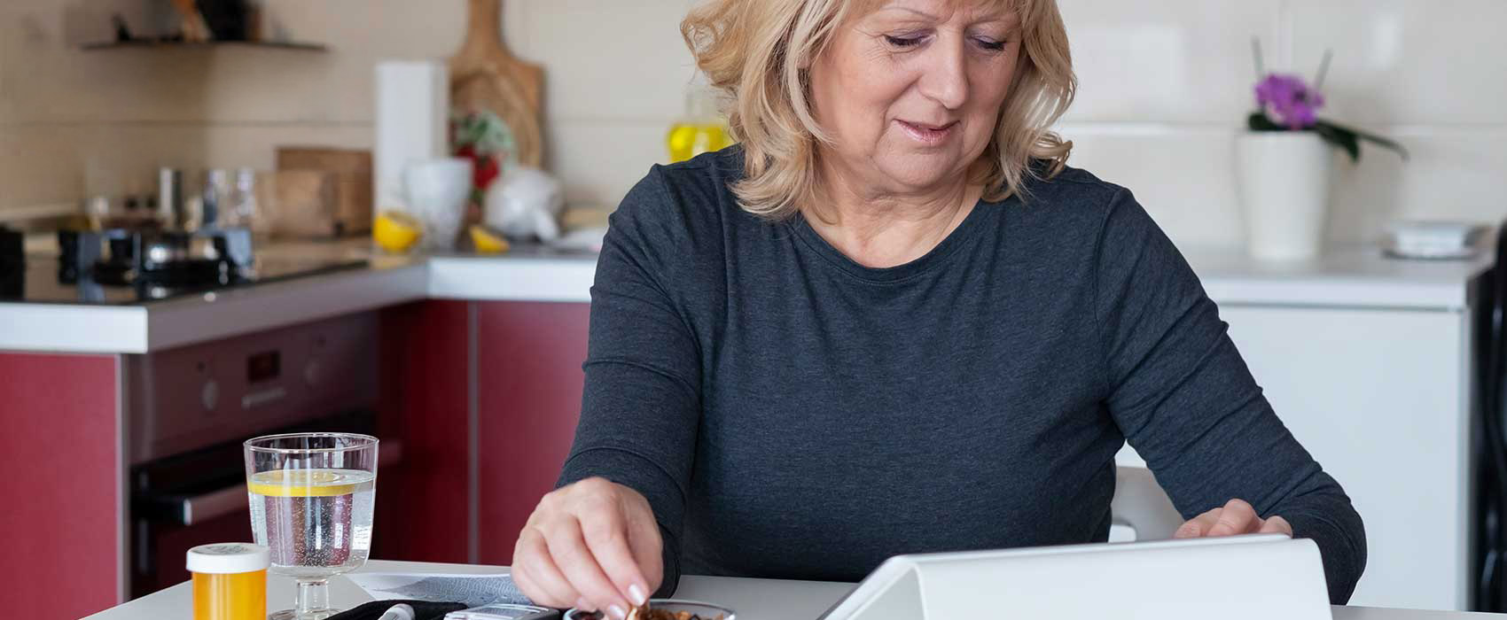 Woman eating while looking at her laptop.