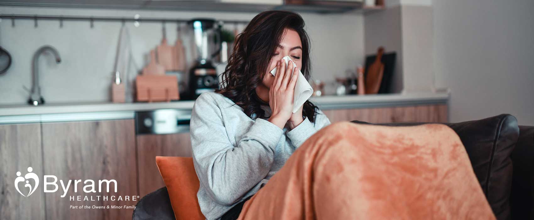 Woman sneezing into a napkin.