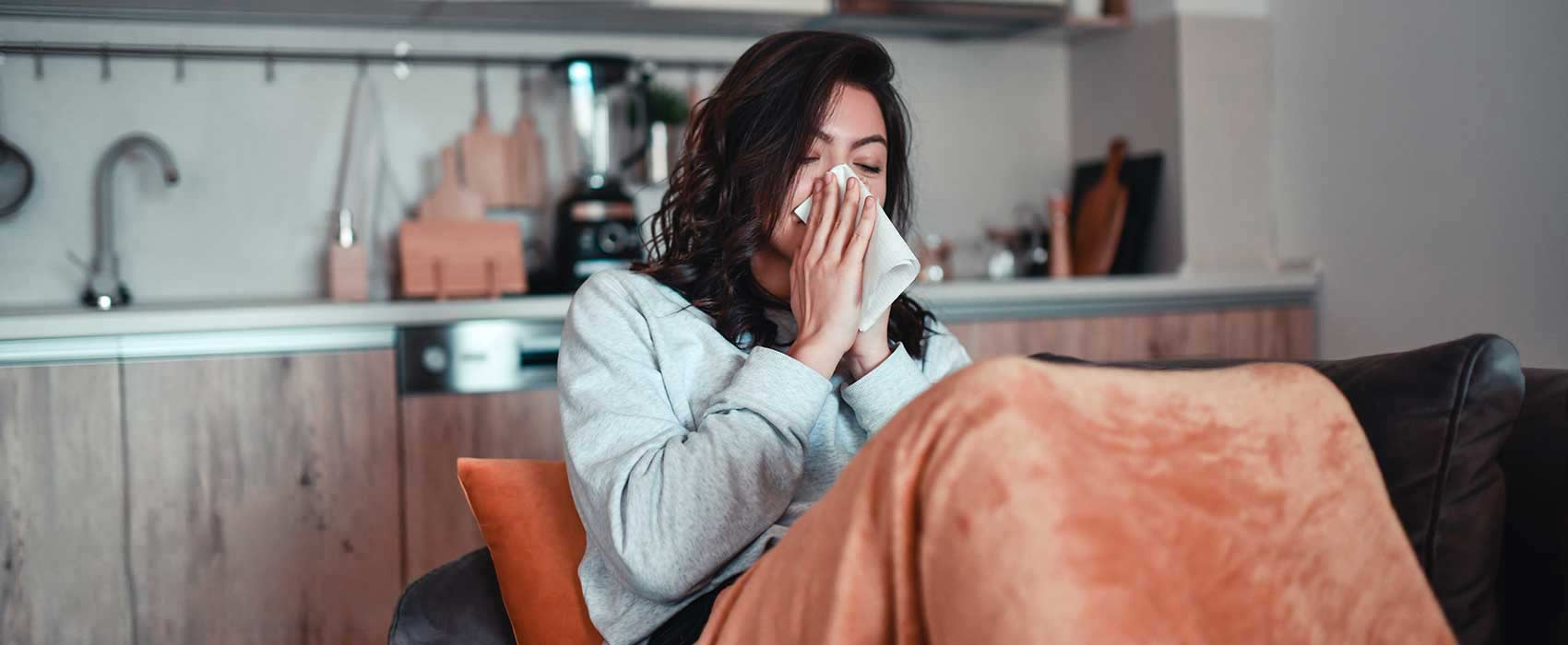 Woman sneezing into a napkin.