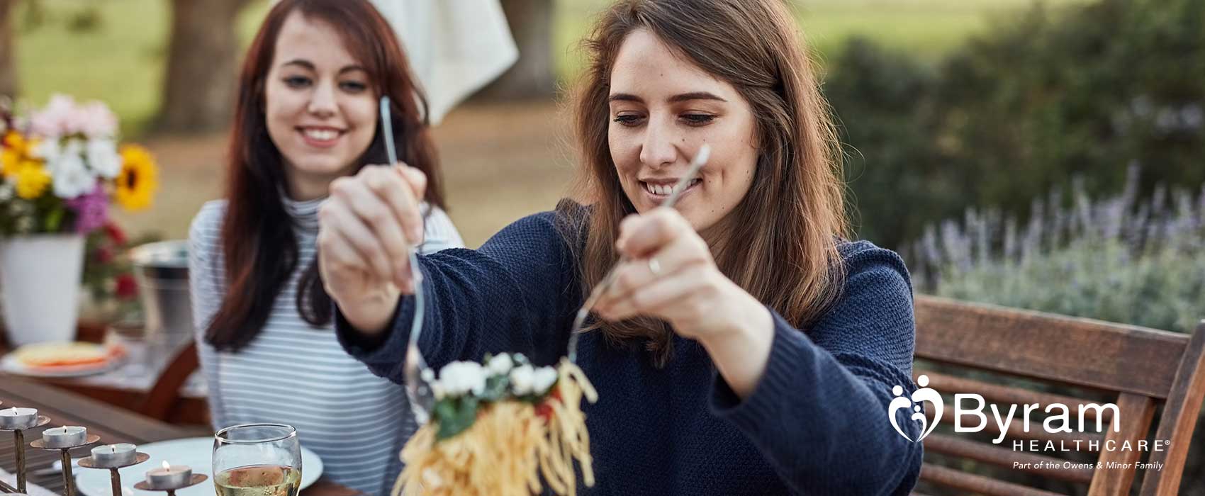 Woman putting pasta on her plate.