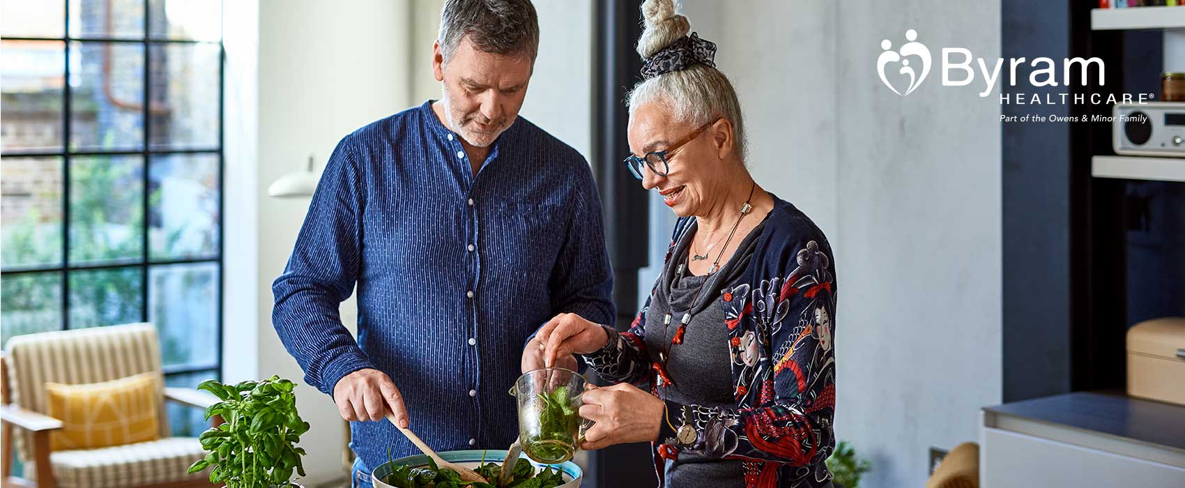 Couple making salad in their kitchen.