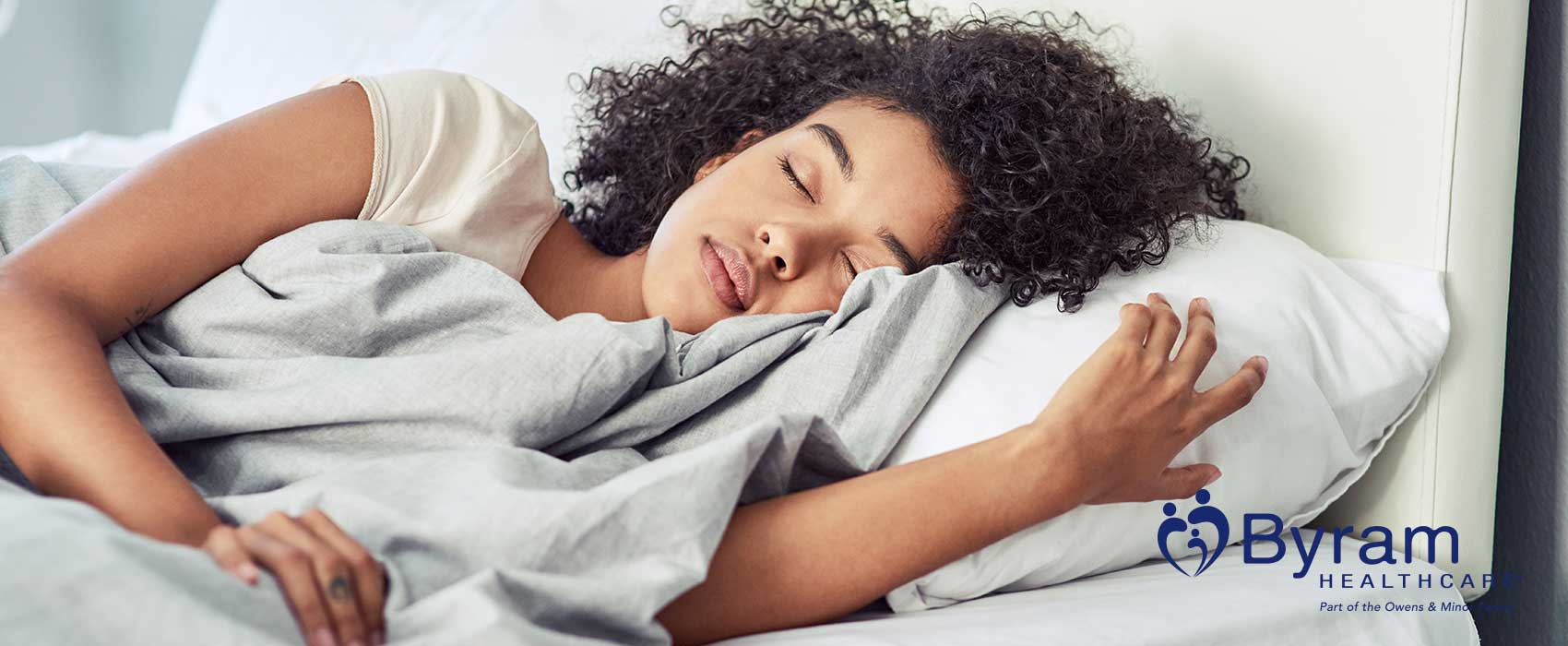 Woman sleeping in a white bed.