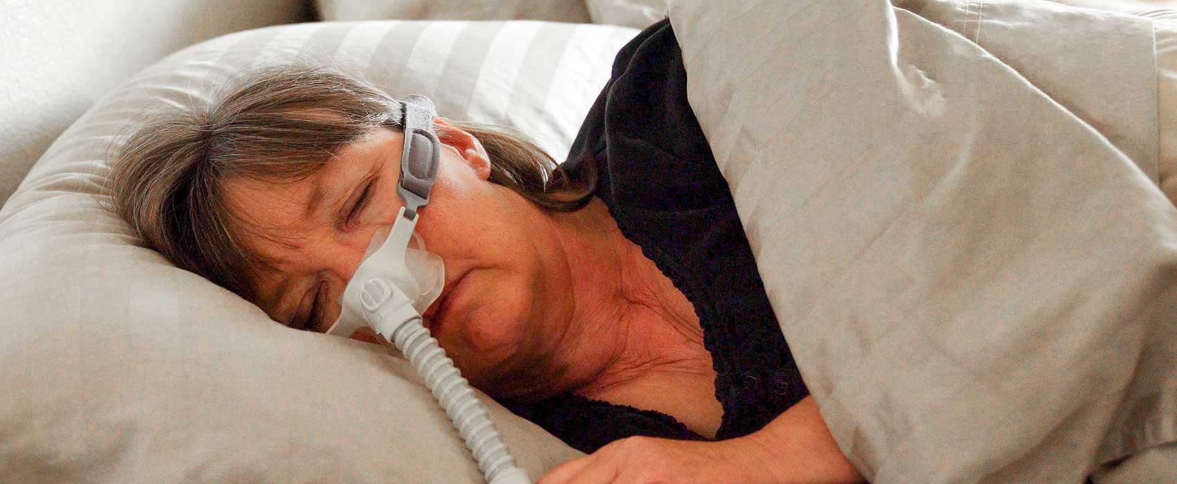 woman in bed with c-pap mask