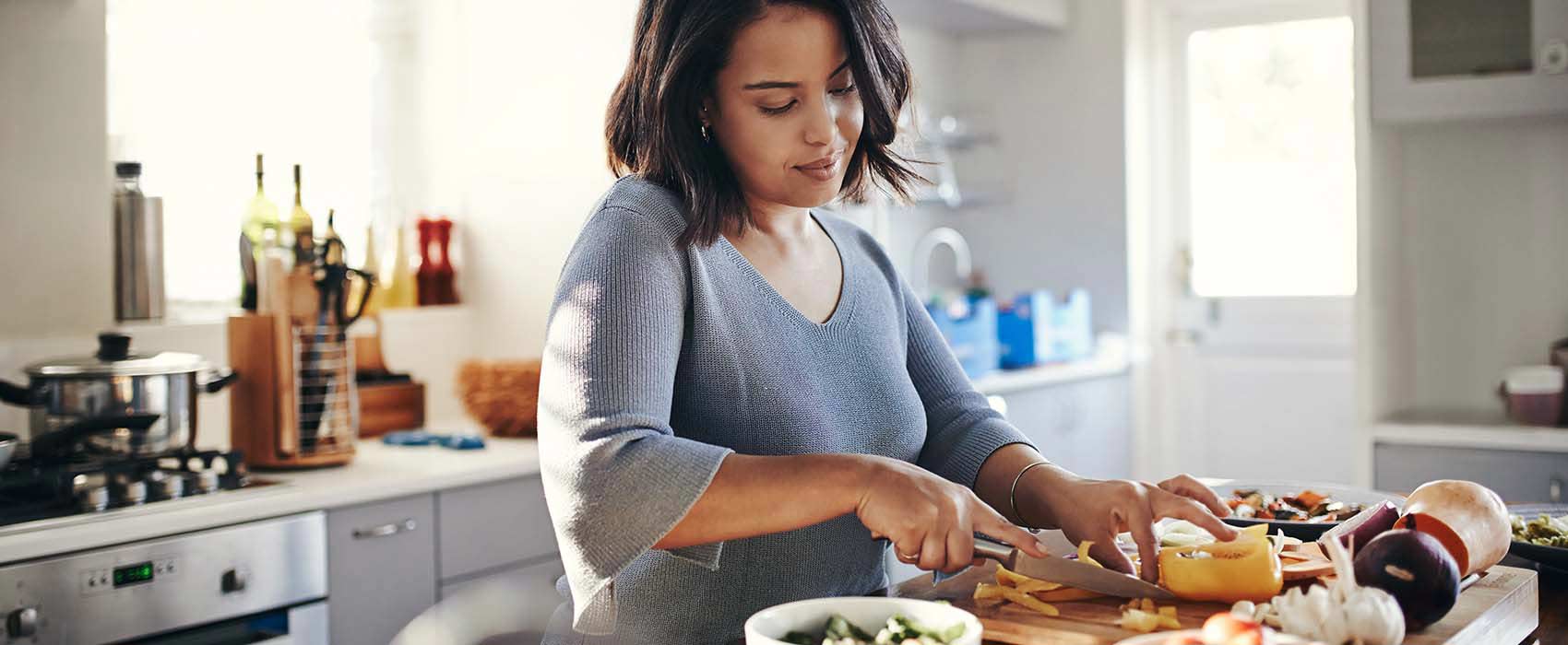 Woman preparing a meal in her kitchen.