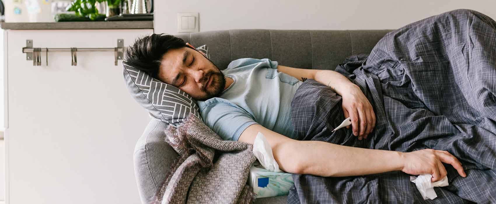 Sick man sleeping on a couch.