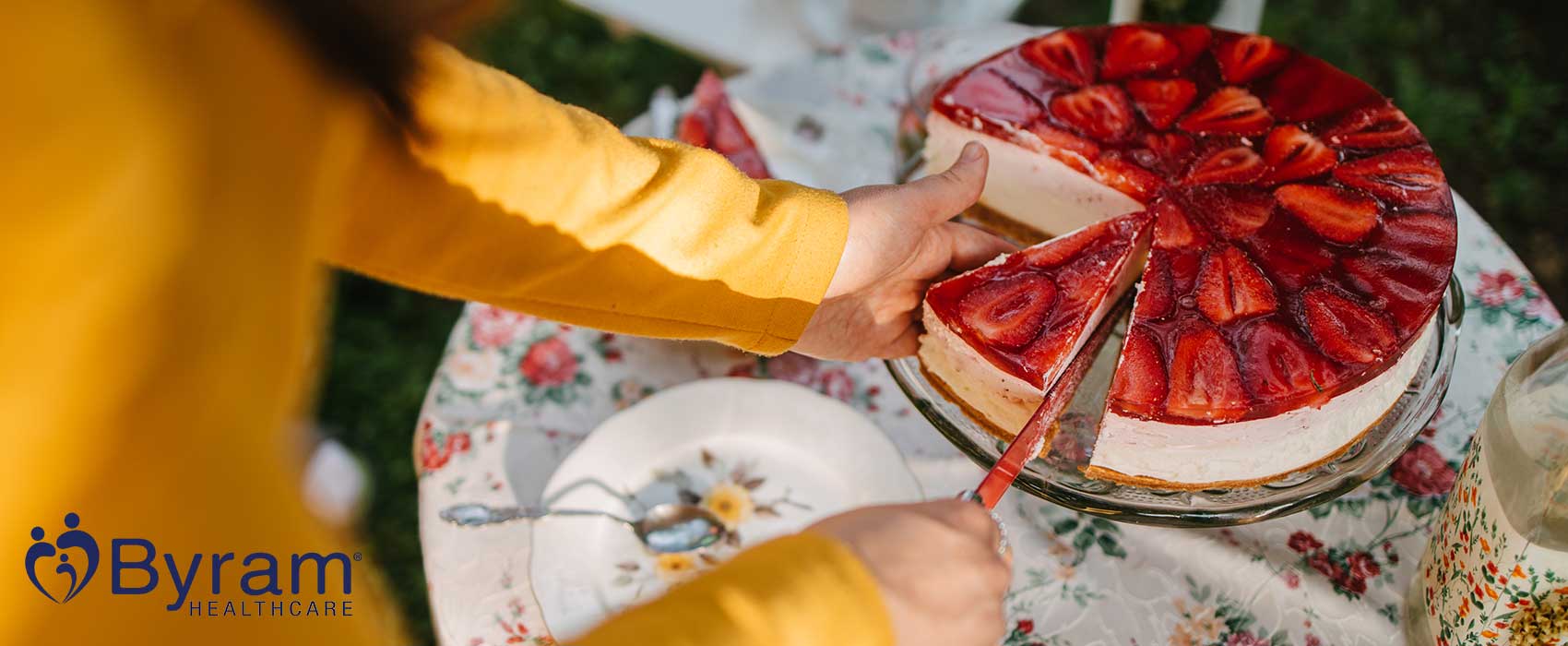 Woman cutting a slice of strawberry cheesecake.