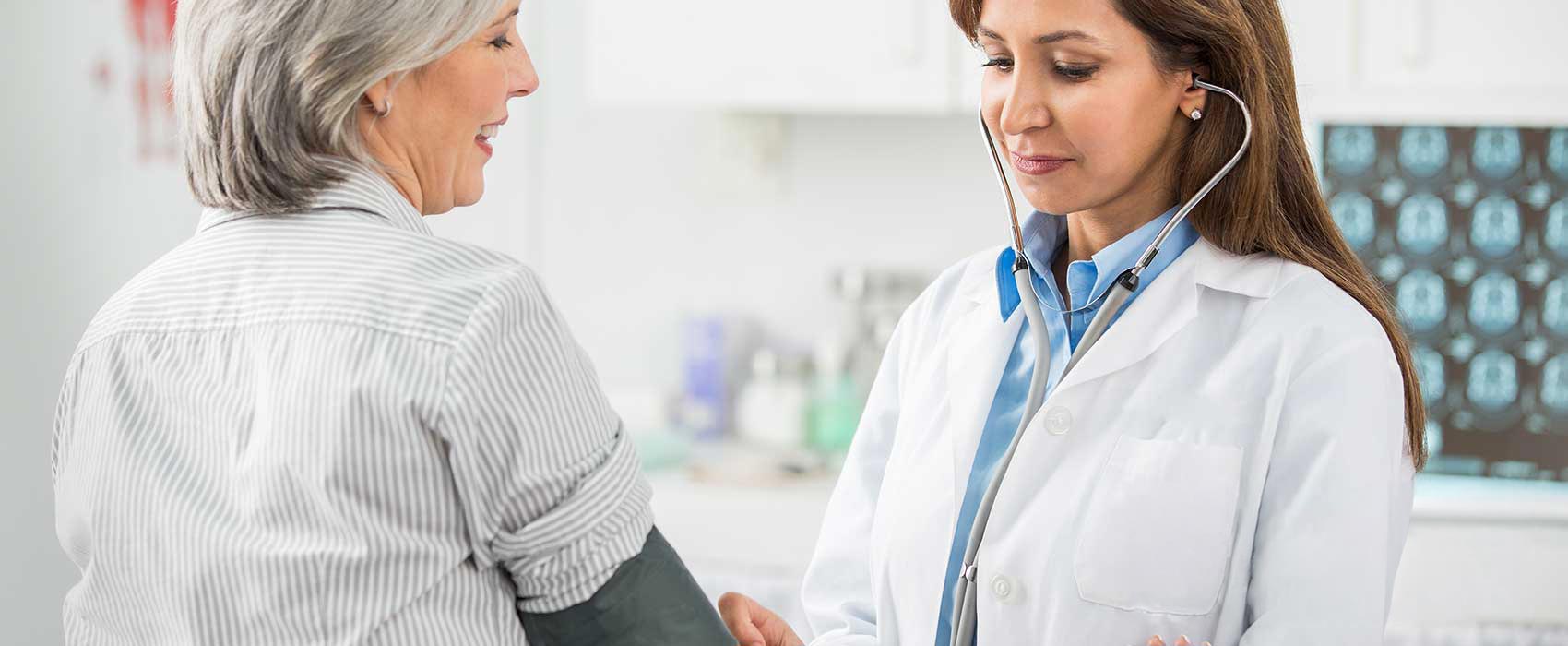 Doctor using stethoscope on patient.