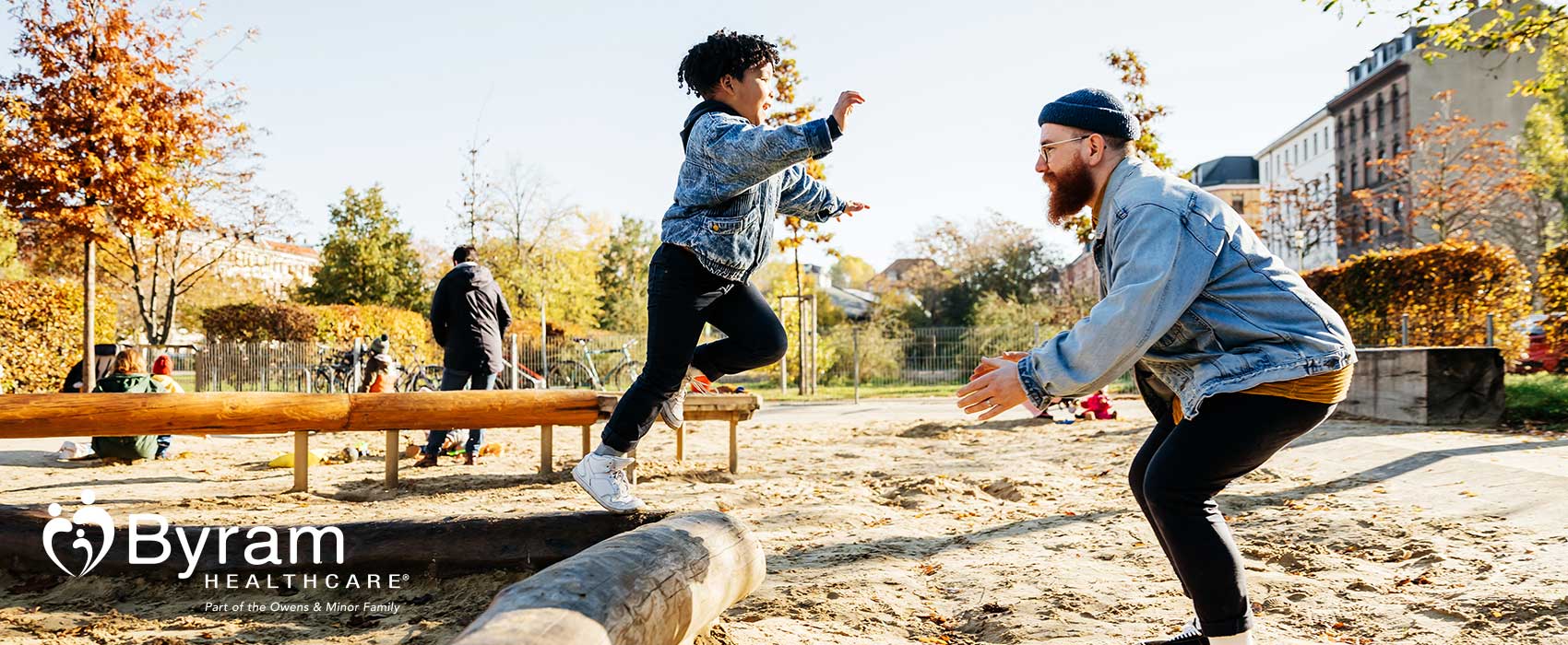 Dad playing with his son on a playground.