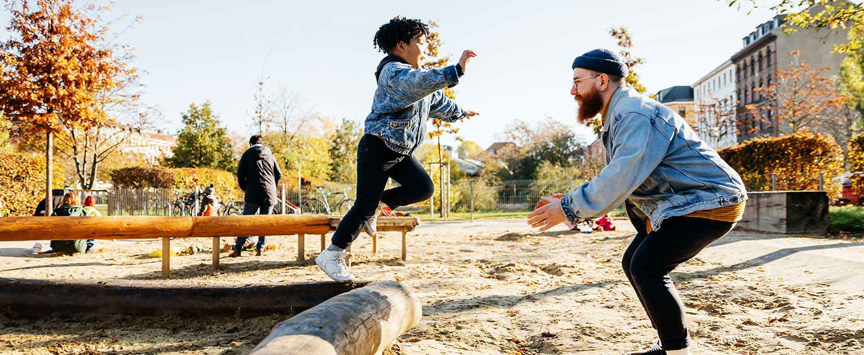 Dad playing with his son on a playground.