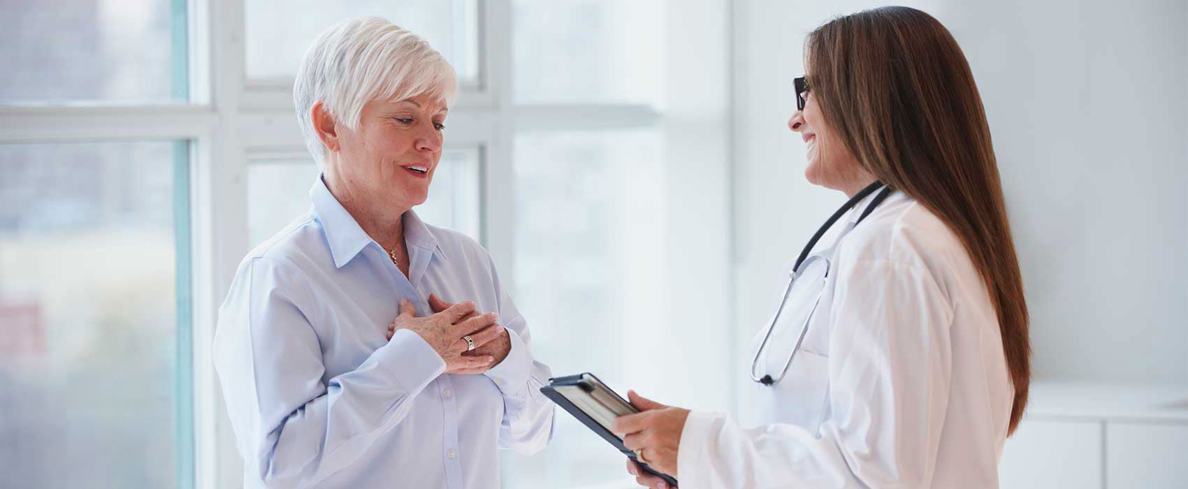 grey-haired woman talks to her doctor