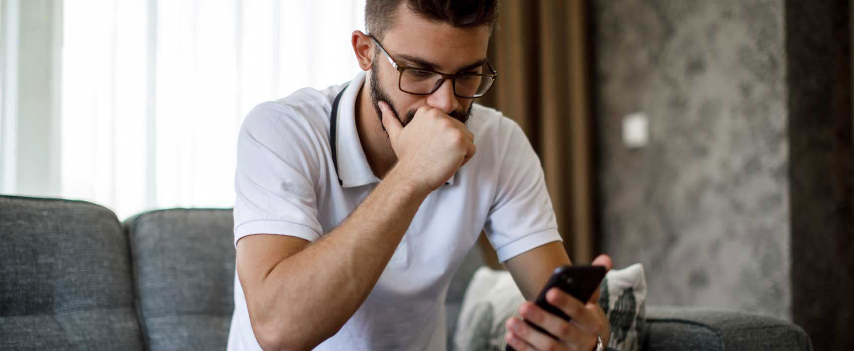 Man sitting on his couch looking frustrated.