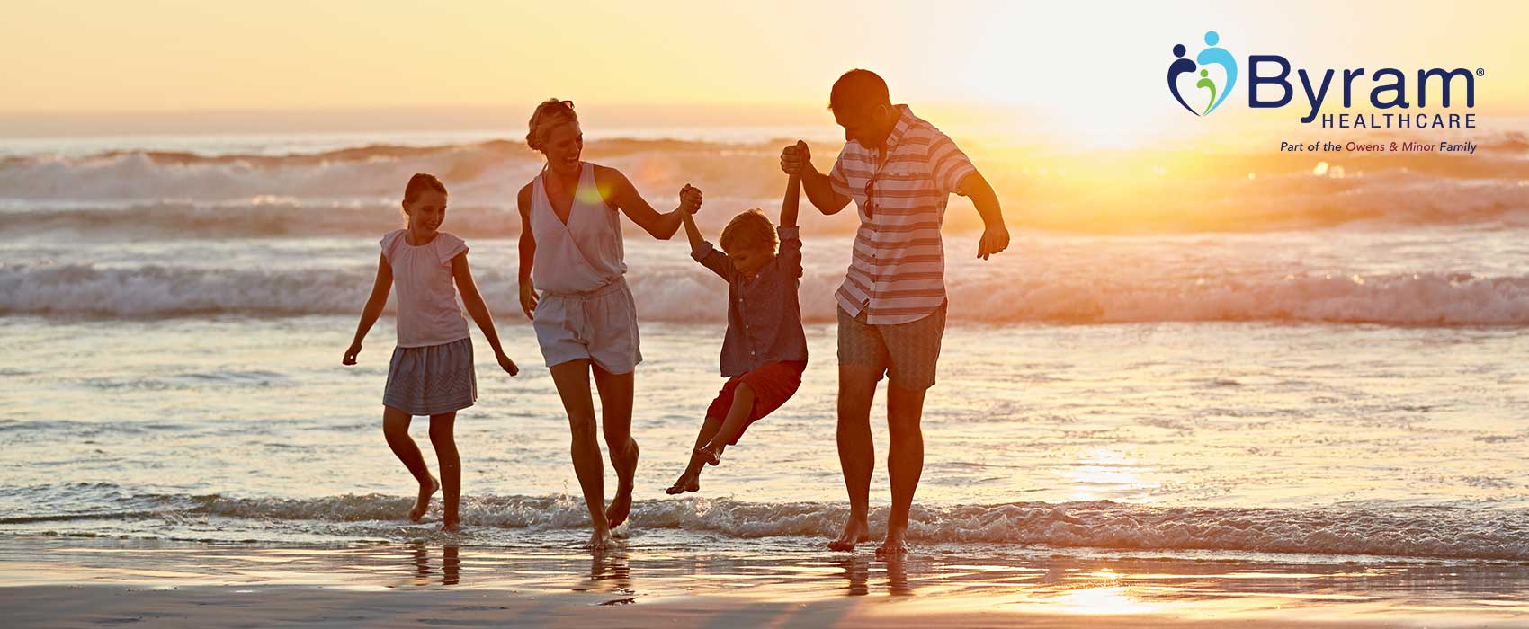 Family walking on the beach during sunset.