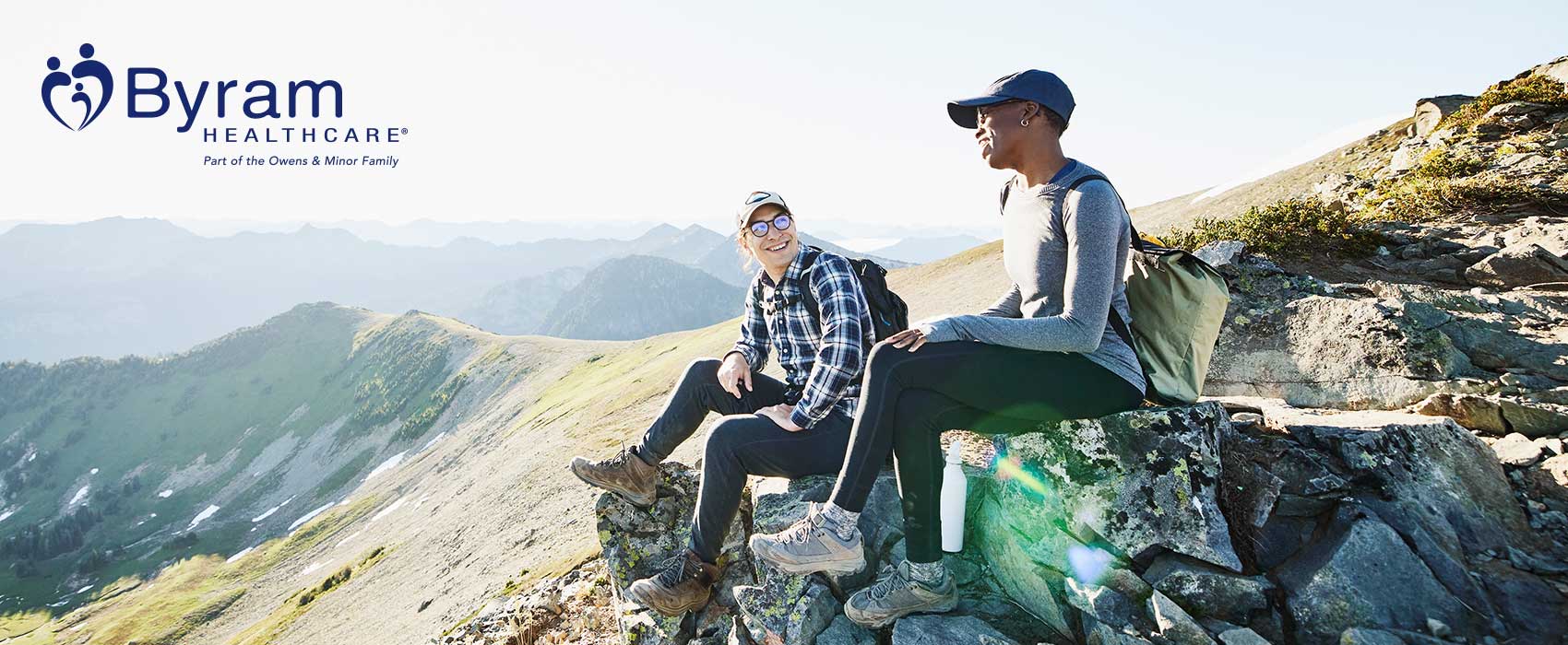 Two people sitting on a mountain.