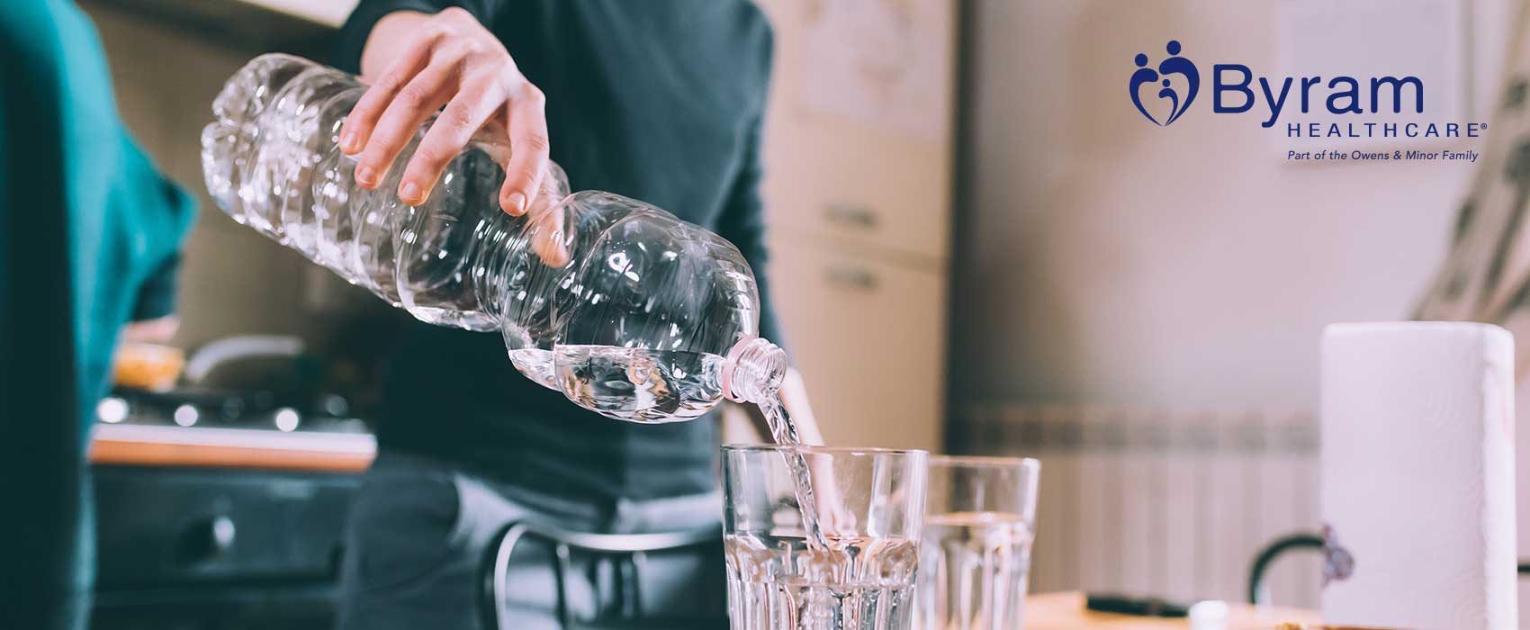 Person pouring a glass of water.