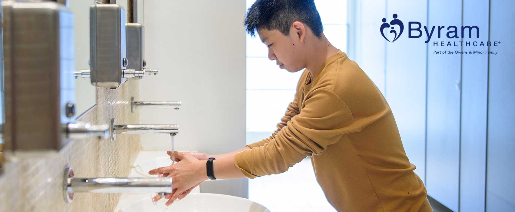 Man washing his hands in a public restroom