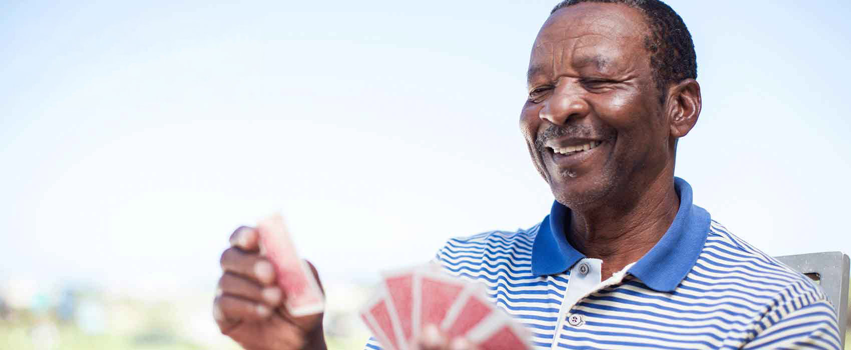 Smiling Man Playing Cards Outside
