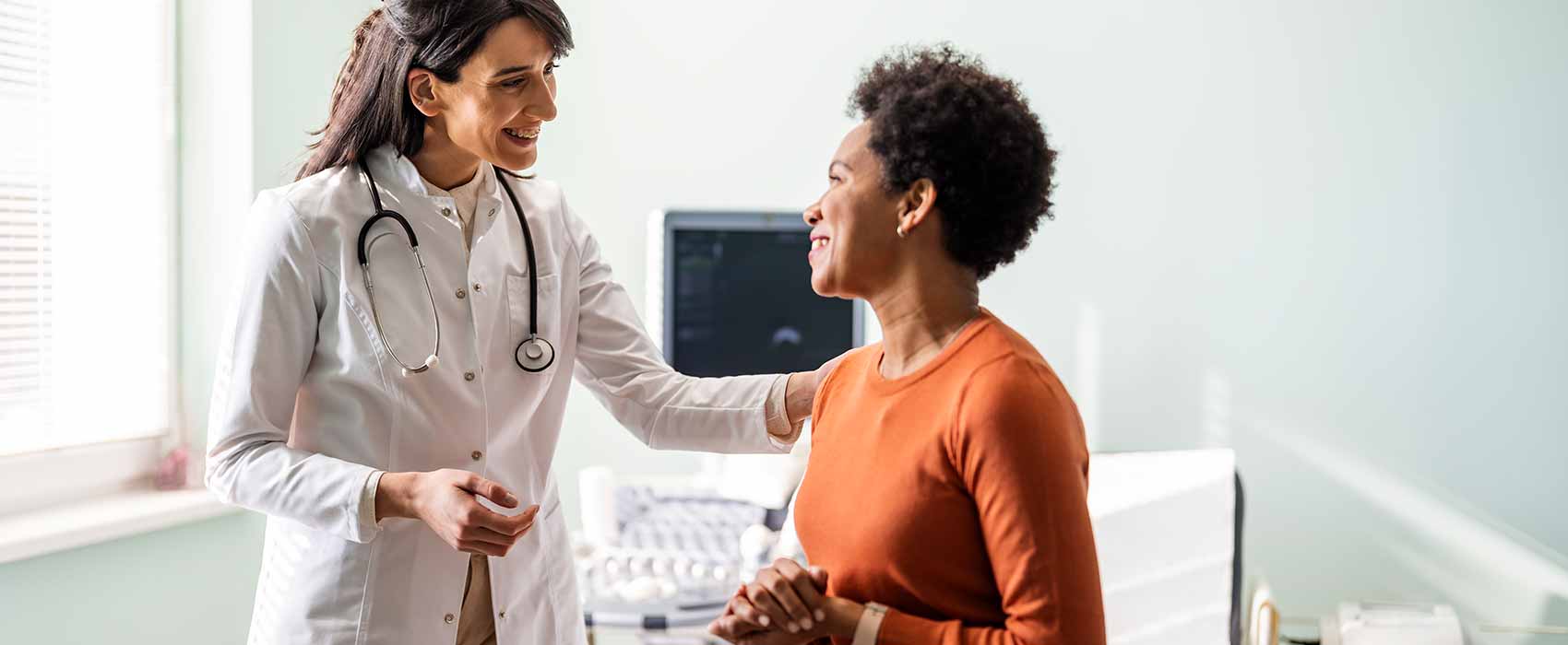 Urologist and patient smiling at each other.