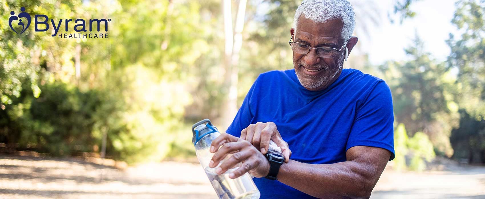 Man holding a water bottle and checking his watch.