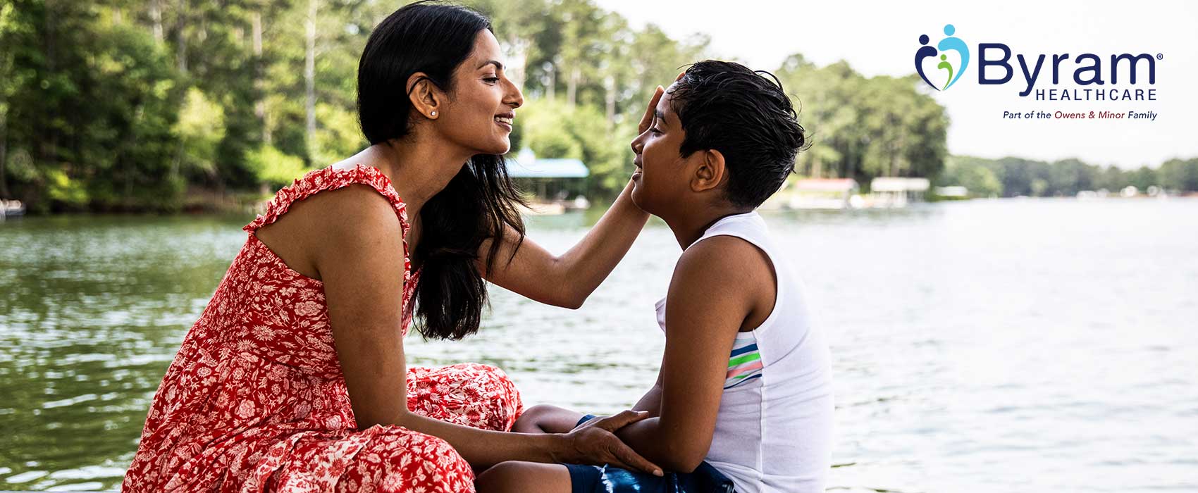 Mom sitting on a dock with her son.