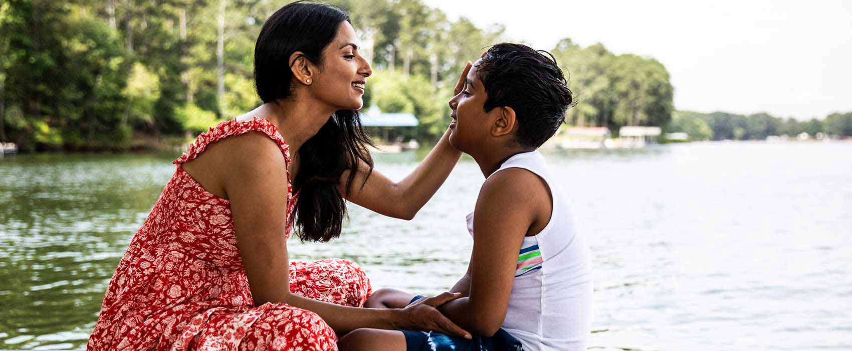 Mom sitting on a dock with her son.