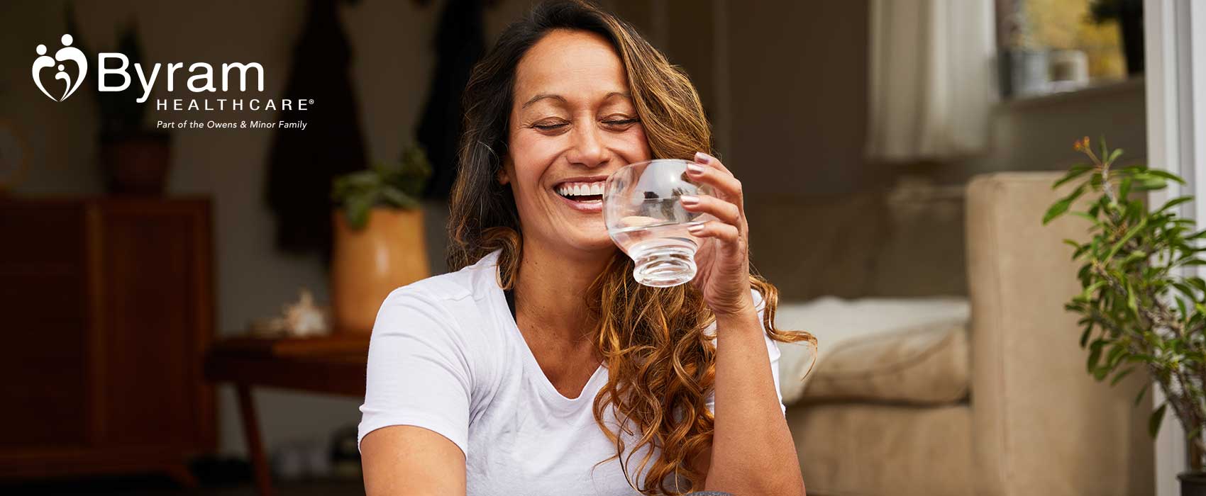 Woman laughing and drinking water.