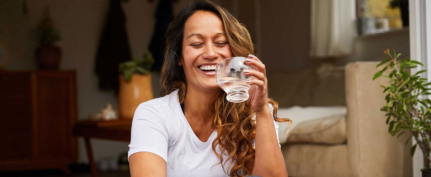Woman laughing and drinking water.
