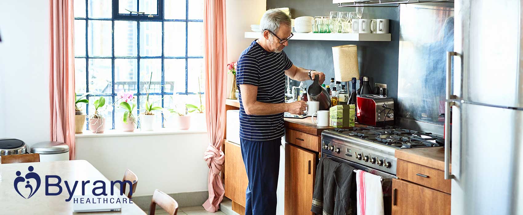 Man pouring himself a drink in his kitchen.