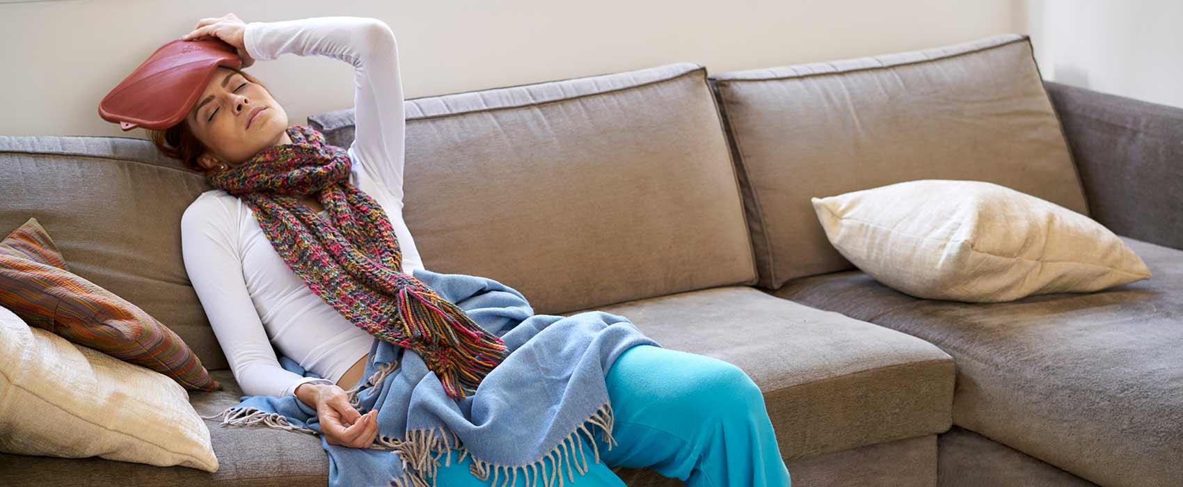 Woman laying sick on the couch.