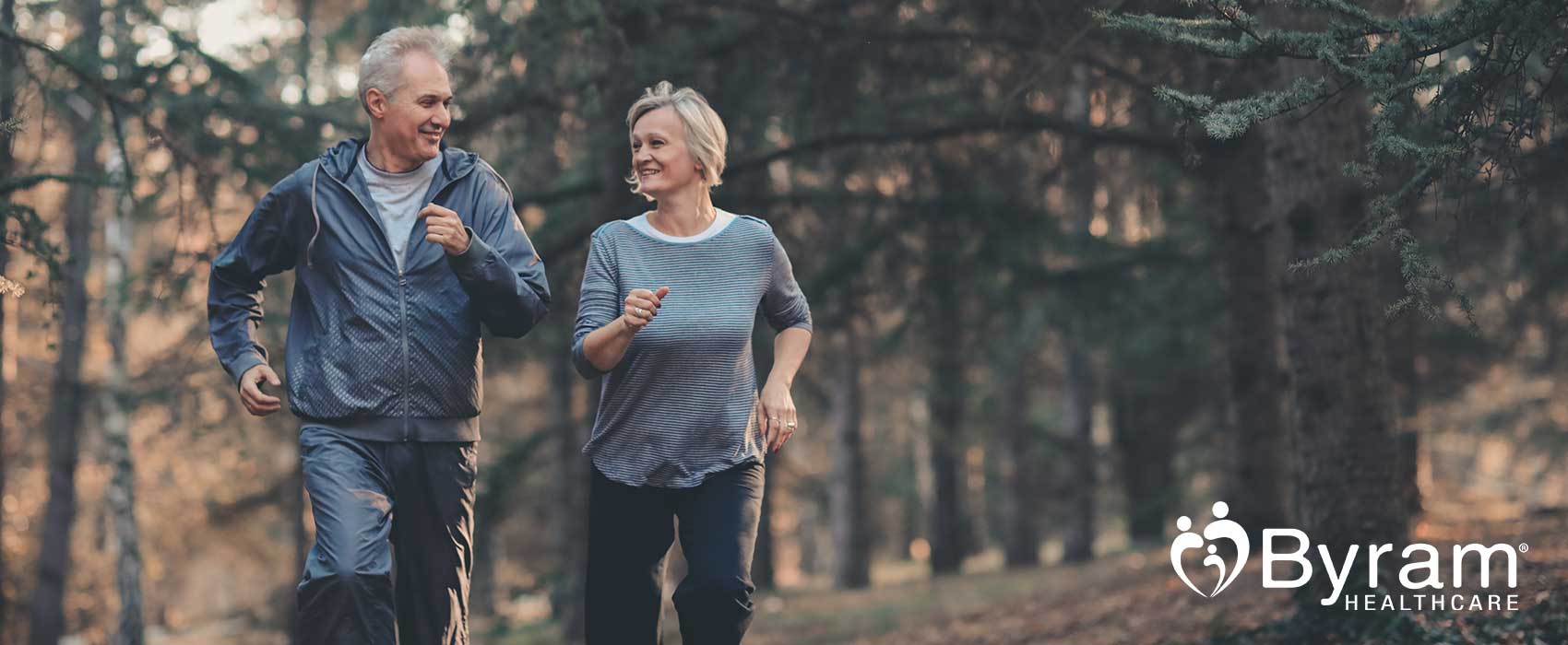 Man and woman jogging in a forest.