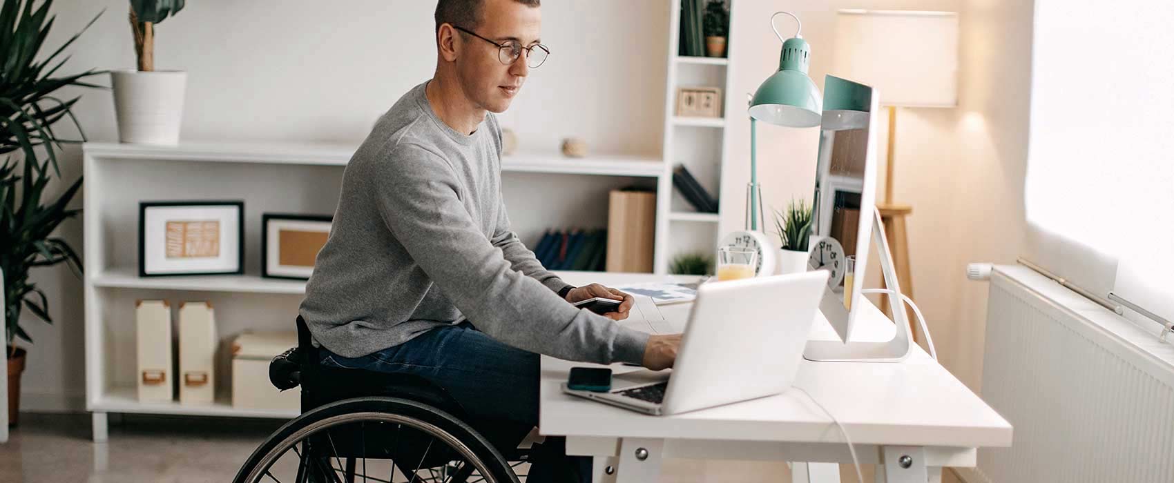 Man working at his desk in a wheelchair.