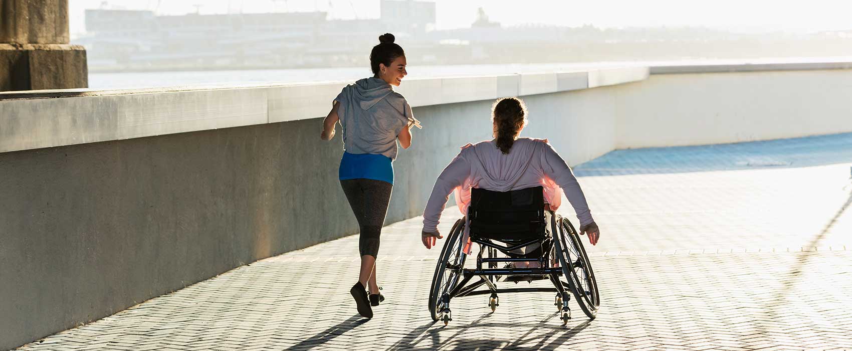 woman running with man in wheelchair