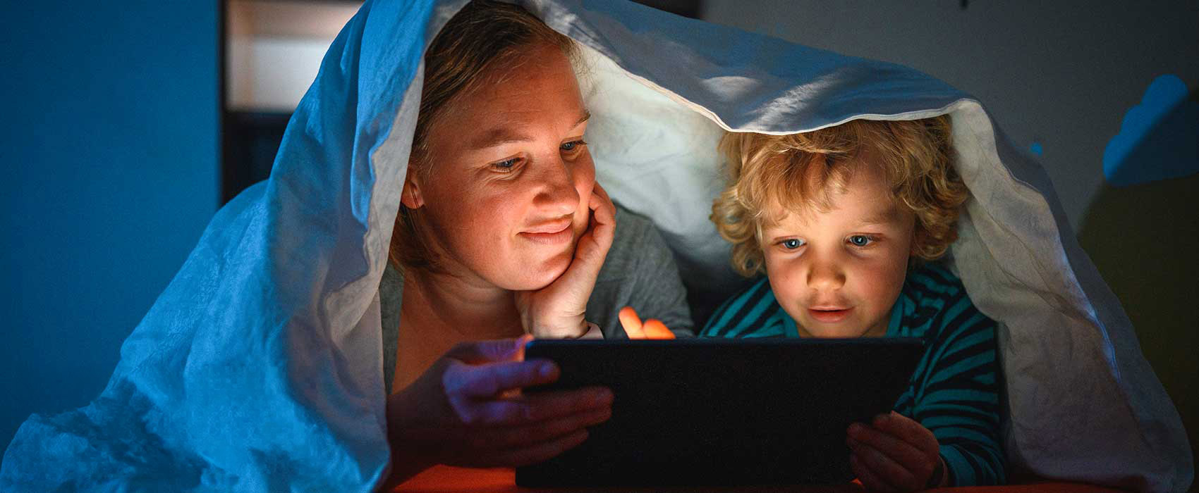 Mom and son reading a bedtime story on a tablet.