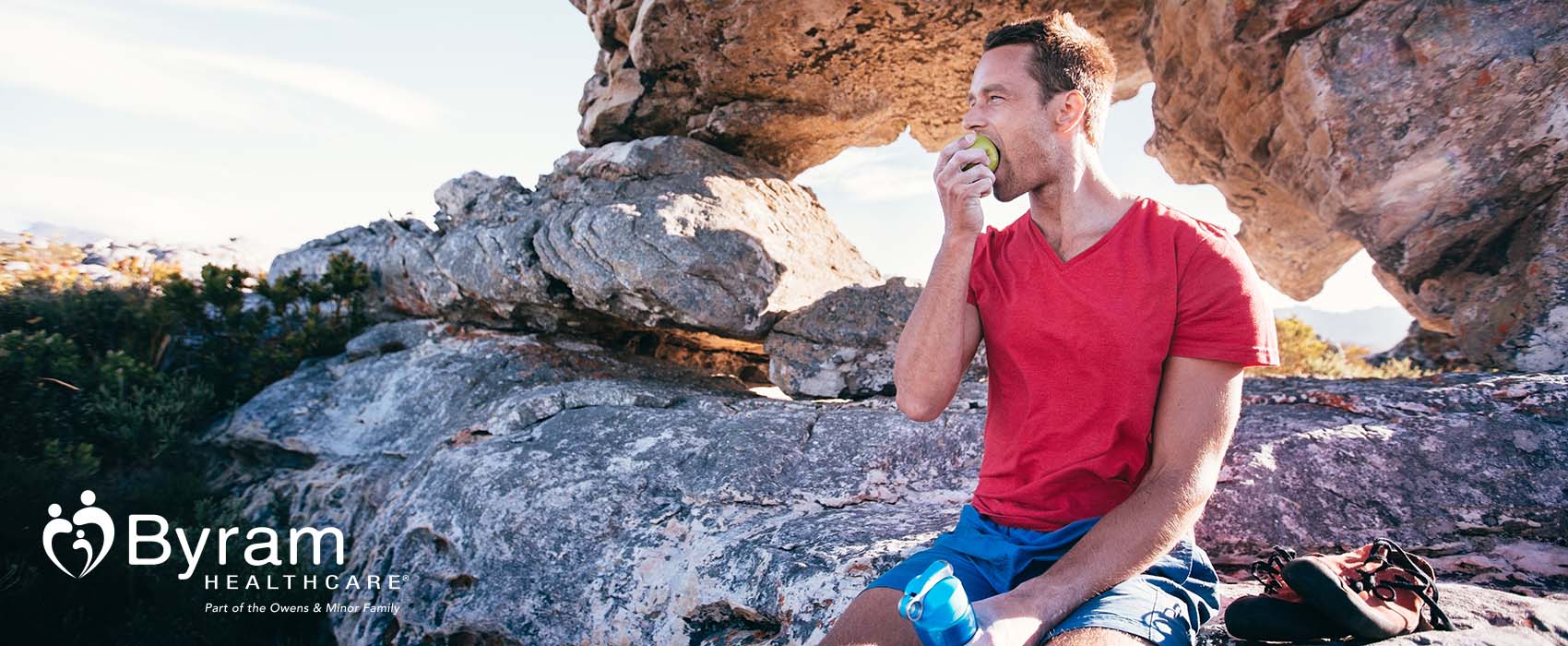 man eating apple on mountain