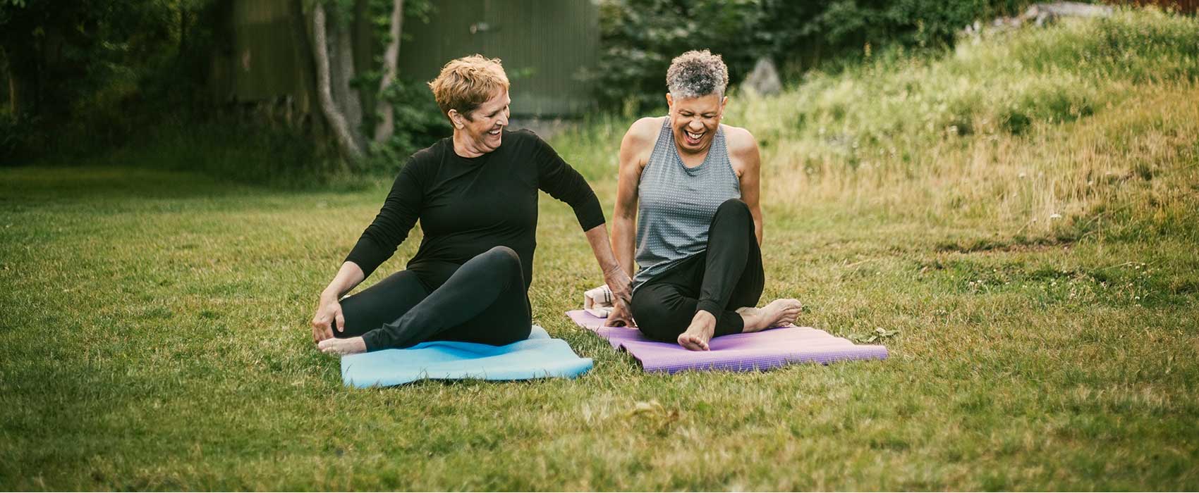 Two older women doing yoga.