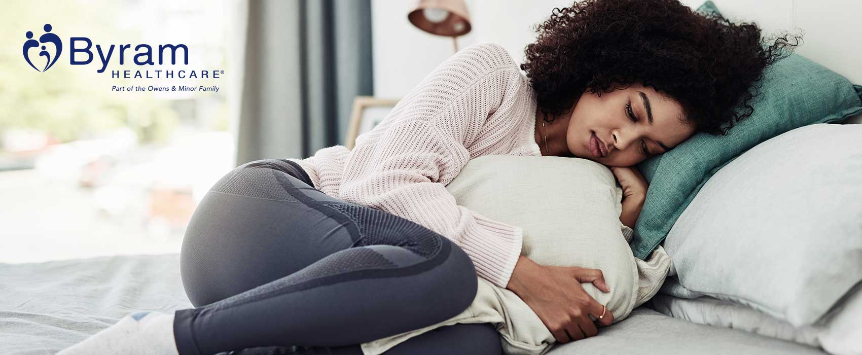 Woman in pain laying on her side.