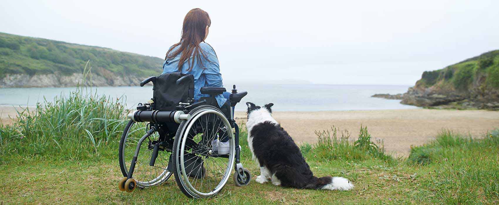 Woman in a wheelchair by a lake.