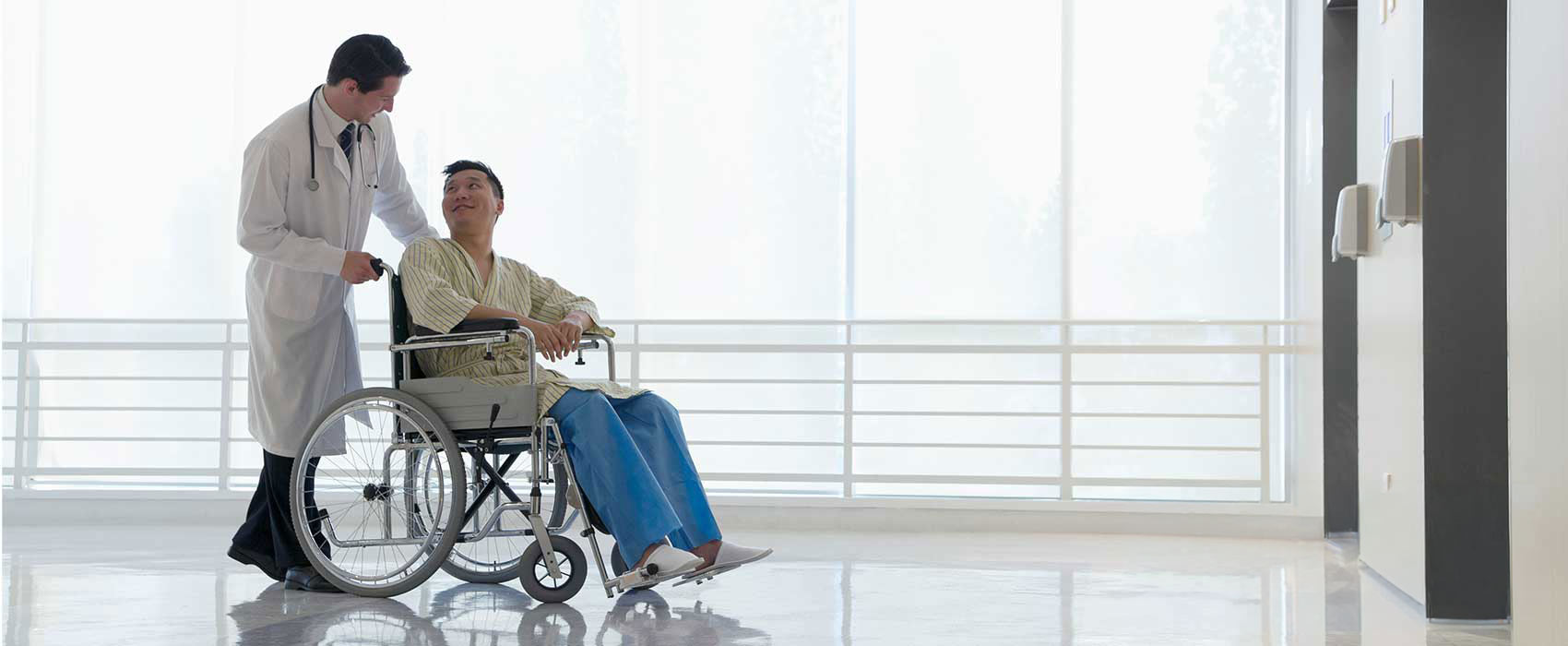 Nurse pushing patient in a wheelchair after surgery.