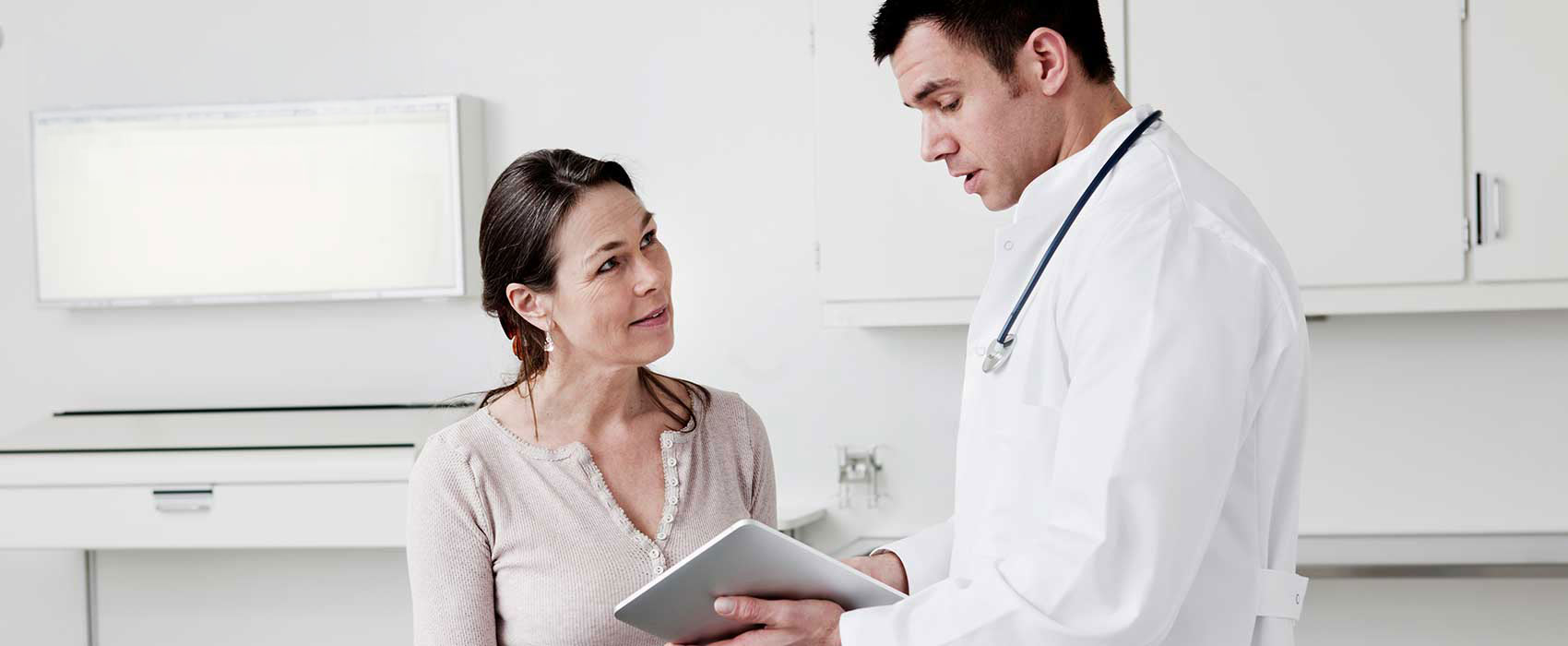 Doctor showing his patient information on a tablet.