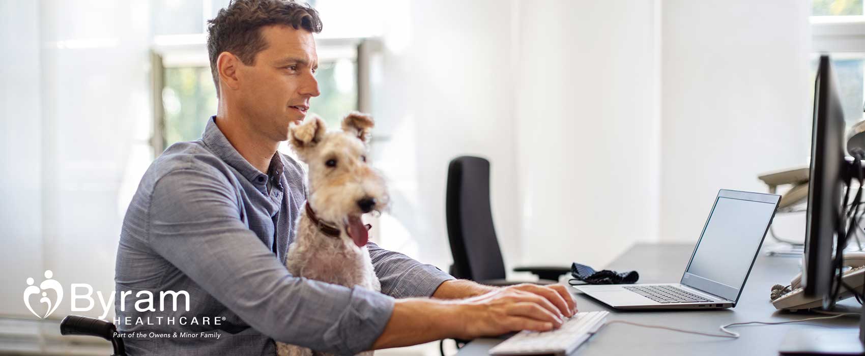 Man in a wheelchair typing on his laptop.