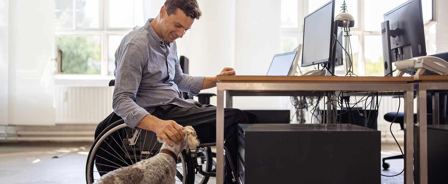 Man in a wheelchair petting his dog
