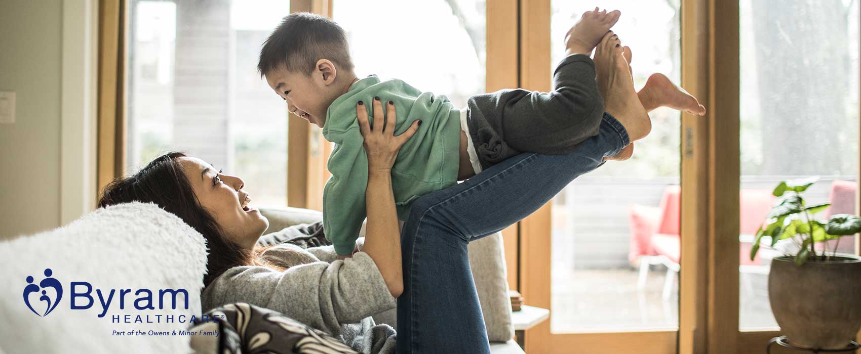 Woman picking up her young child.