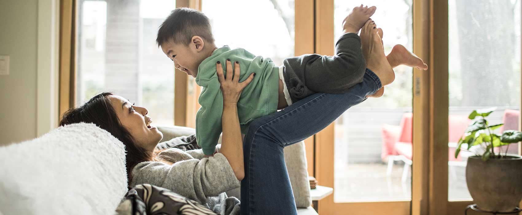 Woman picking up her young child.