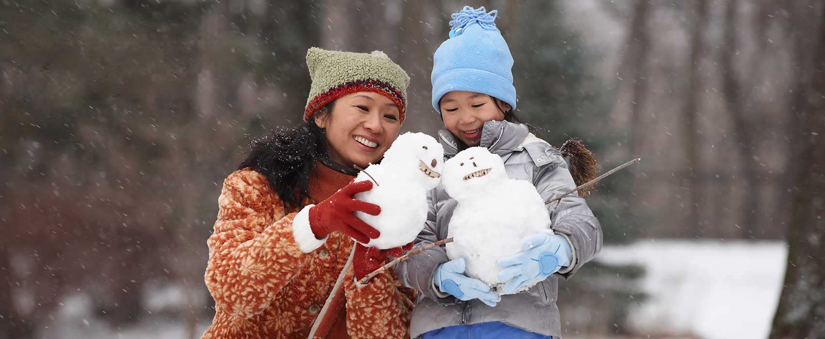 Mom and daughter building snowmen