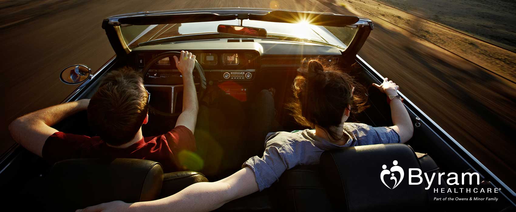 Man and woman driving in convertible