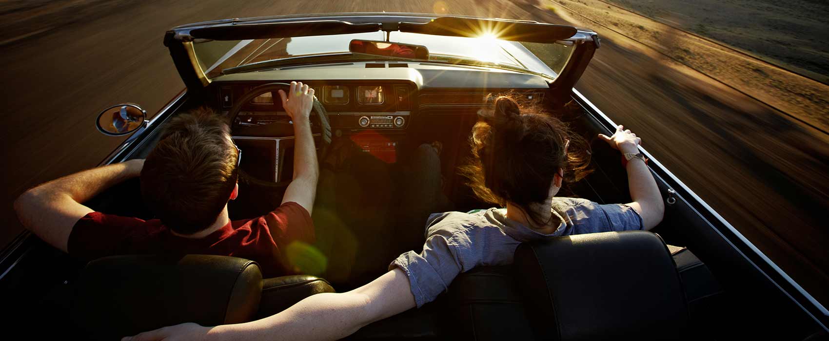 Man and woman driving in convertible