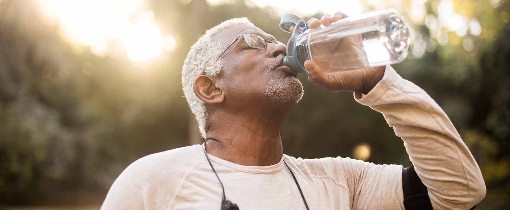 Man outside drinking water.