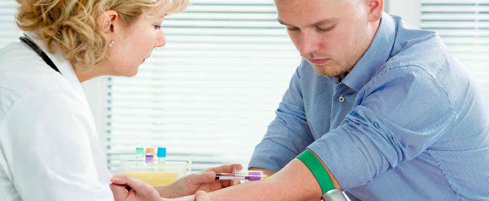 Female healthcare professional giving shot to young man